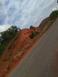 Road by trees against sky