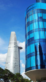 Low angle view of skyscrapers against cloudy sky