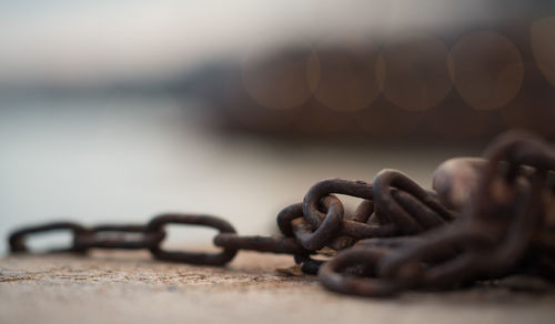 Close-up of chain tied up on metal surface