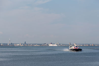 Ship in sea against sky in city