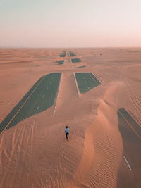 Man walking on desert against sky
