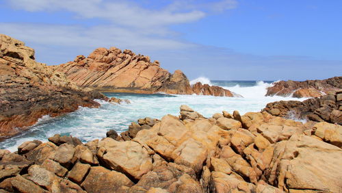 Rocks by sea against sky