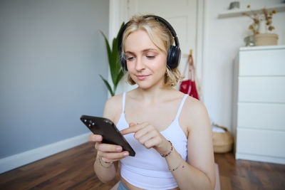 Young woman using mobile phone at home