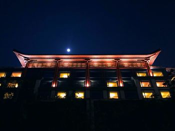 Low angle view of illuminated building against sky at night