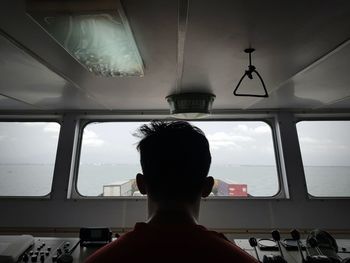 Rear view of man sitting in airplane