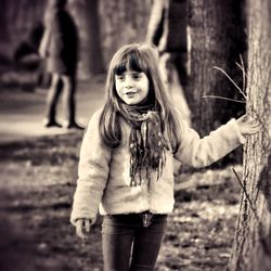 Smiling girl looking away while standing outdoors
