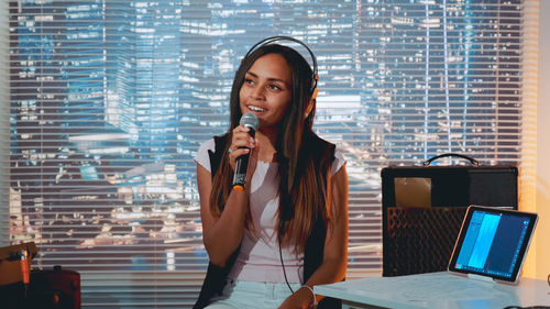 Portrait of young woman using mobile phone in cafe