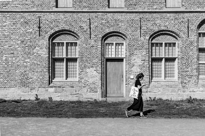 Full length of woman standing against building