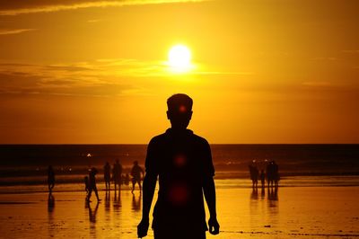 Silhouette man at beach during sunset