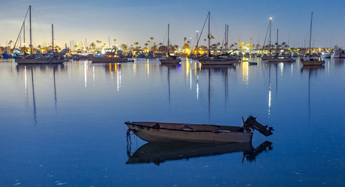 Boats moored in harbor at dusk