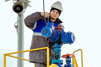 Low angle view of man standing against clear sky