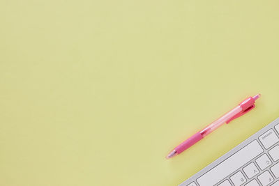 High angle view of pencils on table against yellow background