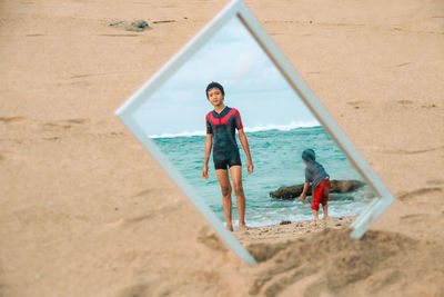 Full length of friends on shore at beach