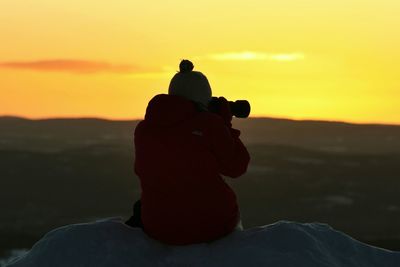 Silhouette of people on mountain against sky during sunset
