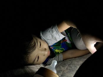 Close-up of young woman sleeping in darkroom