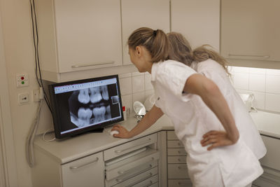 Dentist looking at x-ray on screen