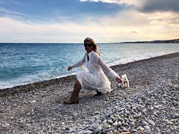 Full length of young woman standing on beach