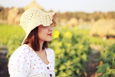Portrait of woman wearing hat on field