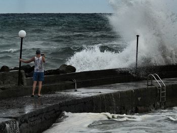 Full length of man standing at sea shore against sky