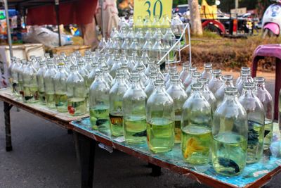 Fishes in bottles with water on table at market