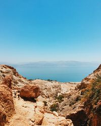 Scenic view of sea and mountains against clear blue sky