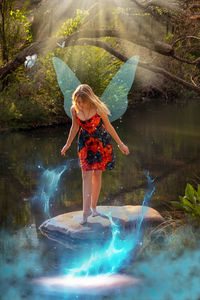 Full length of woman standing by lake