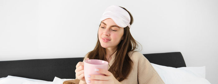 Young woman using mobile phone while sitting at home