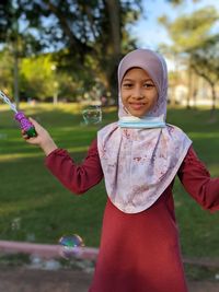 Portrait of a smiling girl holding bubbles