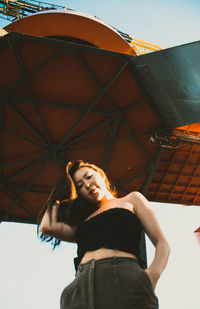 Portrait of young woman standing against wall