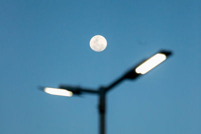 Low angle view of light bulb against clear blue sky