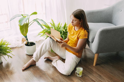 Portrait of young woman sitting on sofa at home