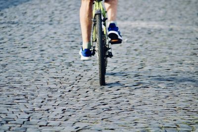 Low section of person riding bicycle on street