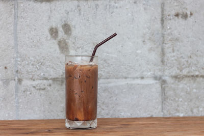 Close-up of drink on table against wall