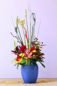Flower vase on table against white background