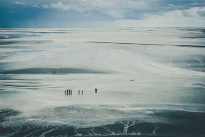 Scenic view of people walking on glacier