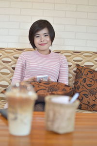 Portrait of a smiling young woman sitting at home