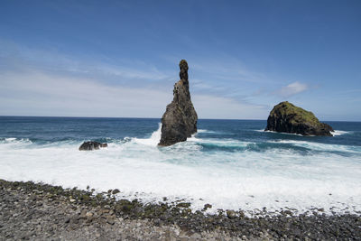 Scenic view of rocks on beach against sky