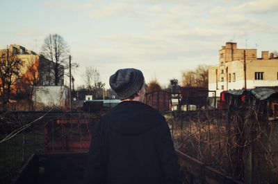 Rear view of man standing in front of buildings at town