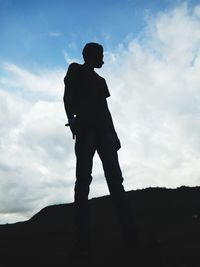 Low angle view of silhouette man standing against sky