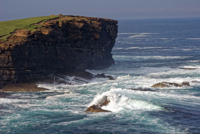 Rock formation in sea against sky