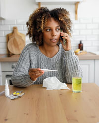 Portrait of smiling young woman sitting on table