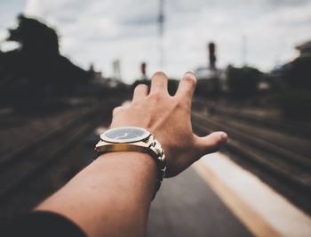 Cropped hand on railroad tracks