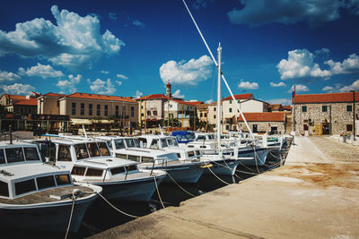 Boats moored in harbor against buildings in city