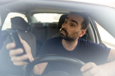 Man using mobile phone in car