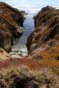 Scenic view of sea by cliff against sky