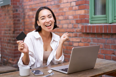 Businesswoman using laptop while sitting on table