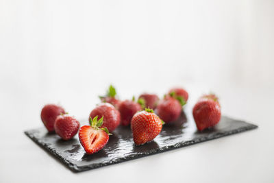 Close-up of strawberries on table against white background