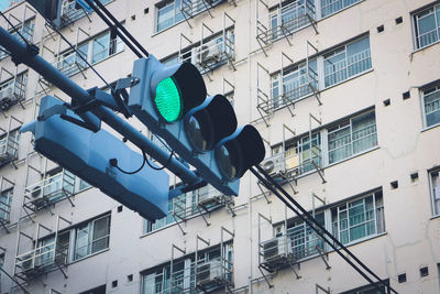 Low angle view of road signal against buildings in city