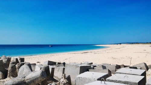 Scenic view of beach against clear blue sky