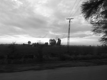 Electricity pylon on field against sky